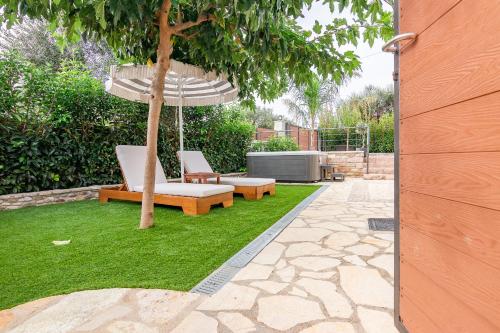 a patio with two benches and an umbrella at Pithea Luxury Living in Koroni