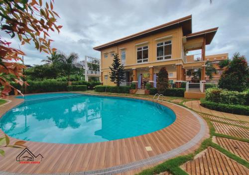 a large swimming pool in front of a house at Affordable Vacation Rental with FREE Pool, Gym and Parking near Puerto Princesa -7Topaz in Puerto Princesa City