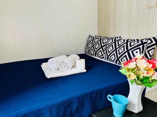 a blue table with towels and a vase with flowers at Sea Residences Tower F Angel in Manila