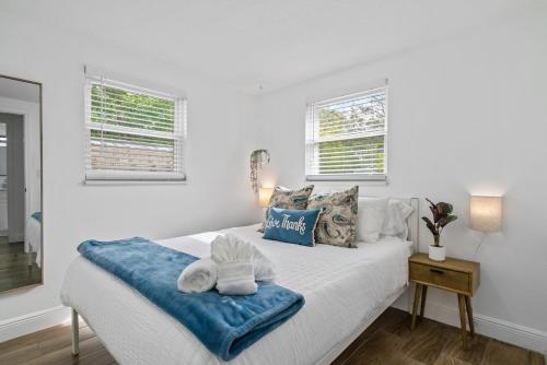 een witte slaapkamer met een bed met handdoeken erop bij The Peaceful Village Unit #1 in Plant City