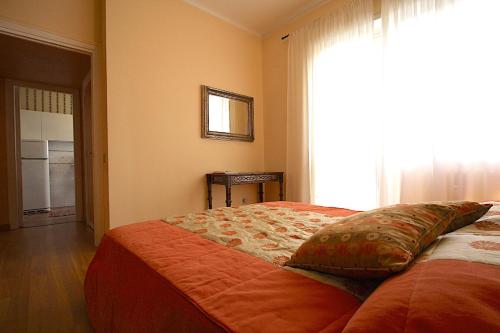 een slaapkamer met een bed met een kussen en een raam bij Corso Francia 1BR in Rome