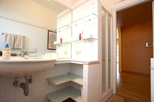 een witte badkamer met een wastafel en een wastafel bij Corso Francia 1BR in Rome