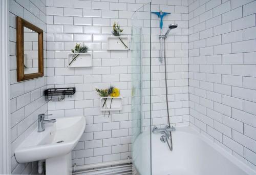 a white bathroom with a sink and a bath tub at Ivy Cottage in Henley on Thames