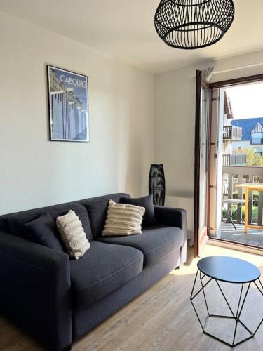- un salon avec un canapé bleu et une table dans l'établissement Le Balbec - Appartement Cosy, à Cabourg