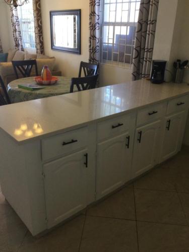 a kitchen island with a white counter top at Villa Riana Barbados in Christ Church