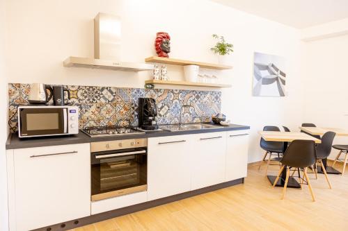 a kitchen with white cabinets and a microwave at FLORIANA B&B in Nuova Gibellina