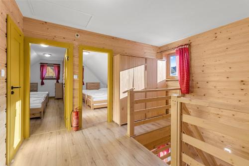 a wooden room with two beds and a bedroom at Chata Kukaňa in Stará Lesná