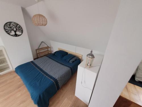 une chambre avec un lit et une table de chevet dans l'établissement Le jardin de lumière -chambre2, à Pontchâteau