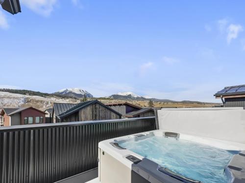 a hot tub on a balcony with mountains in the background at 541 Center Circle 3Br 3,5Ba townhouse in Silverthorne