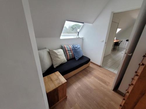 - un petit salon avec un canapé et une fenêtre dans l'établissement Le jardin de lumière -chambre2, à Pontchâteau
