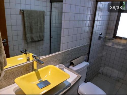 een badkamer met een gele wastafel en een toilet bij Flat Fabuloso - Porto de Galinhas - Malawí Beach Resort in Porto De Galinhas