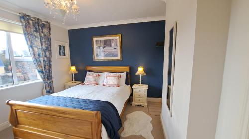 een slaapkamer met een bed en een blauwe muur bij Hillhead House in Ardara