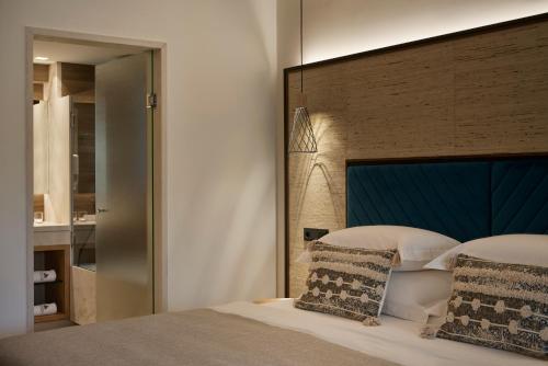 a bedroom with a large bed with a blue headboard at Atlantica Aegean Blue in Kolimbia