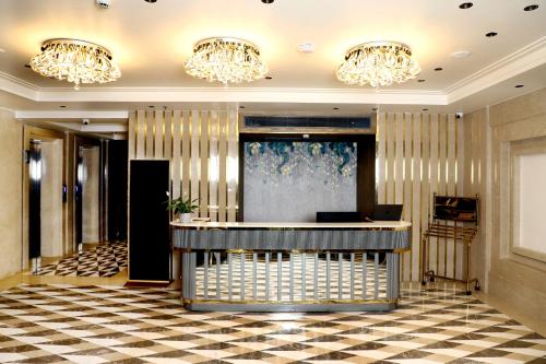 a lobby with a reception desk and chandeliers at BluSalzz Residence Amritsar in Amritsar