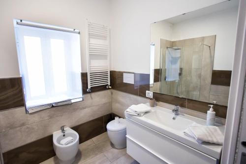 uma casa de banho com um lavatório, um WC e um espelho. em Palazzo 15 em Nápoles