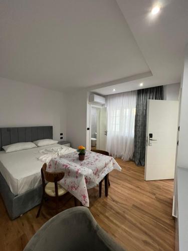 a bedroom with a bed and a table and a bed and a room at Vila Herta - Escape in Durrës