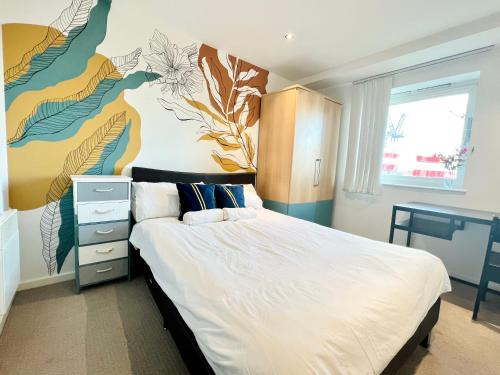 a bedroom with a bed with a flower mural on the wall at AirScape Warm & Cosy Two Bed Apt in Birmingham