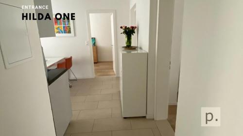 a hallway with a kitchen with a vase of flowers at H1 with 4,5 Room, Bathroom, Kitchen, Central, quiet & modern with office in Zurich