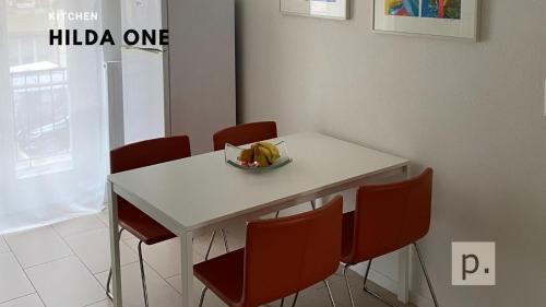 un tavolo bianco con sedie e una ciotola di banane di H1 with 4,5 Room, Bathroom, Kitchen, Central, quiet & modern with office a Zurigo