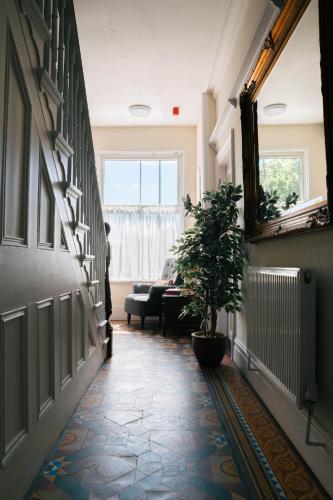 a hallway with a potted plant on the floor at Cranmere Lichfield in Lichfield