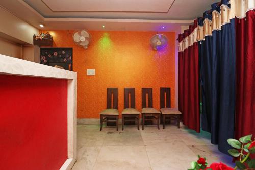 a row of chairs in a room with red and blue curtains at Xpress Inn in Garui