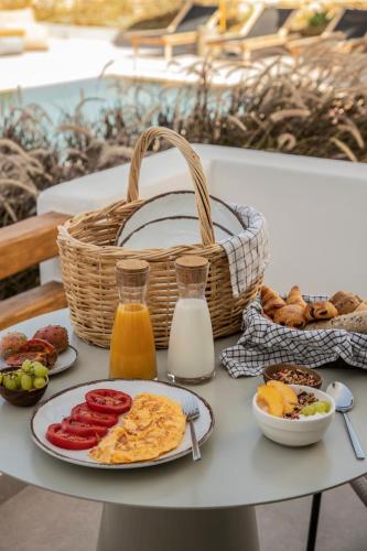 a table with plates of food and a basket of milk at Nysis Koufonisia in Koufonisia