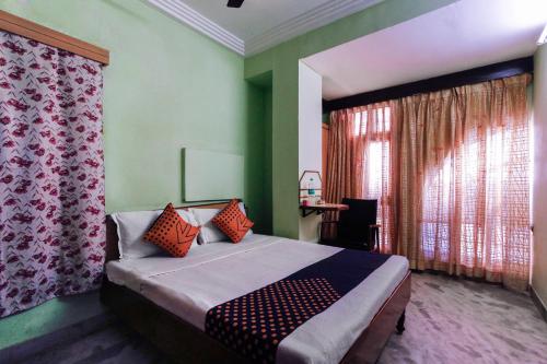a bedroom with a bed and a desk in a room at SPOT ON Hotel Rock View Lodge in Tiruchchirāppalli