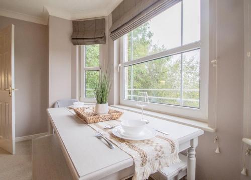 Un comedor con una mesa y una ventana. en Garden View Nook-2 bed apartment, en High Blantyre