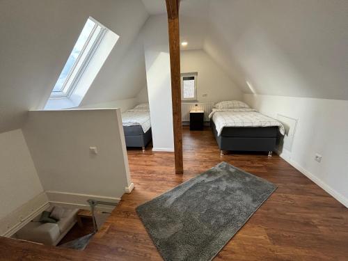 Pokój na poddaszu z 2 łóżkami i dywanem w obiekcie Fichten Apartment w Hanowerze