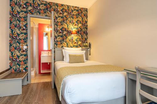 a small room with a bed and a wall at Splendid Hôtel in Paris