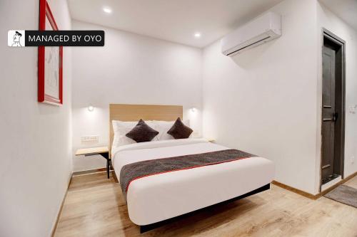 a white bedroom with a bed and a desk at Townhouse Akota Mujmahuda Road - Managed by Company in Vadodara