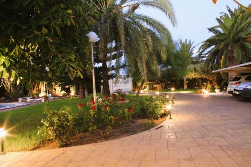 a park with palm trees and flowers and a street light at Villa Iluminada con chimenea, barbacoa y piscina cerca Playa in Elche