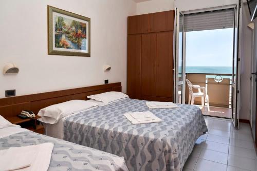 里米尼的住宿－大西洋酒店，酒店客房设有两张床和一个阳台。