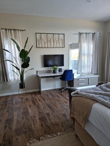 a bedroom with a bed and a desk and a television at Lilitha Boutique Hotel-East London in East London