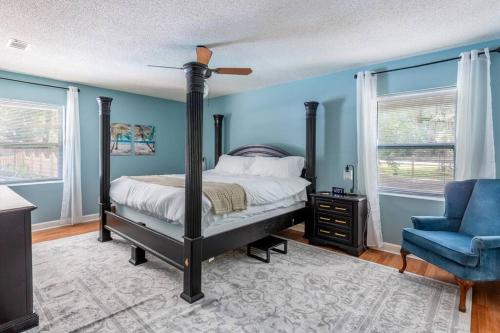 a bedroom with a bed and a blue wall at Golden Isles Lrge Home- Huge Pool, Hot Tub, Game Rm in Brunswick