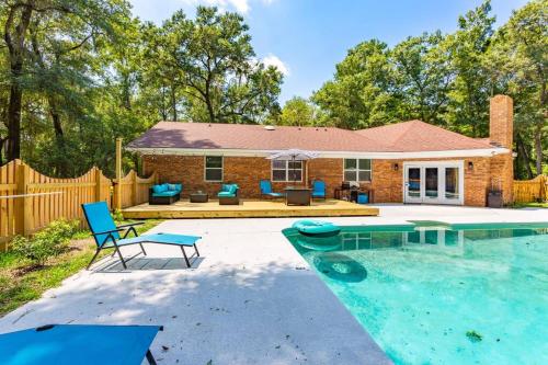 a backyard with a pool and a house at Golden Isles Lrge Home- Huge Pool, Hot Tub, Game Rm in Brunswick