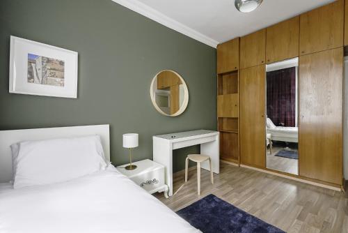 1 dormitorio con cama, escritorio y espejo en Flat with Balcony 5 min to Konyaalti Beach, en Antalya