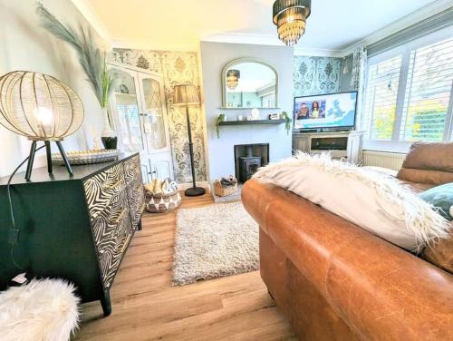 a living room with a couch and a fireplace at Spacious lovely 3 Bed House in Keyworth Nottingham suit CONTRACTORS OR FAMILY in Keyworth
