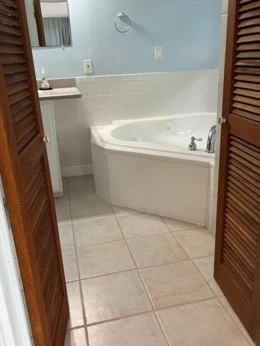 a bathroom with a tub and a tile floor at Royal Palm Villas 