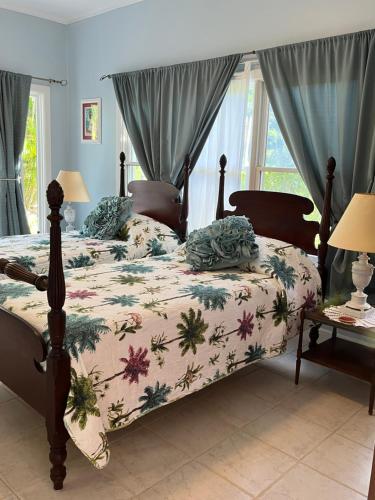 a bedroom with a bed with a comforter with flowers at Royal Palm Villas 