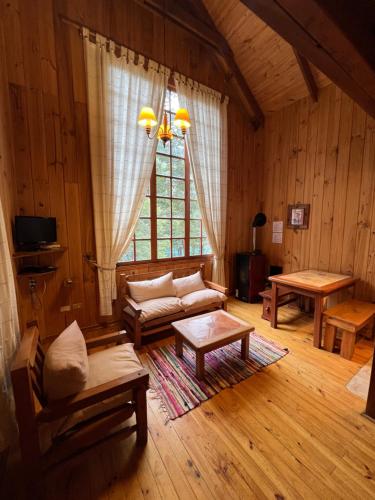 a living room with a couch and a table at Green Baker Lodge in Puerto Bertrand