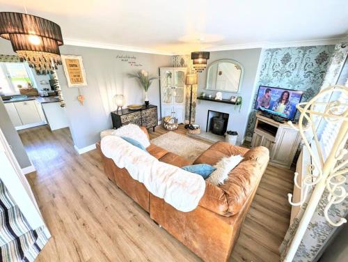 a living room with a couch and a television at Spacious lovely 3 Bed House in Keyworth Nottingham suit CONTRACTORS OR FAMILY in Keyworth