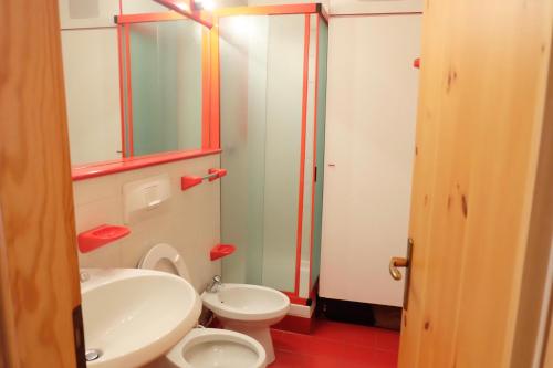 een badkamer met een wastafel, een toilet en een spiegel bij Condominio La Grand'Ourse - Cervinia in Breuil-Cervinia