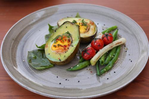 einen Teller mit Eiern und Gemüse auf dem Tisch in der Unterkunft The Zen Wellness Resort in Assuan
