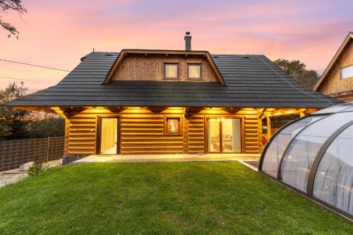 a log house with a greenhouse next to it at Chaty Kukana a Kuku in Vysoké Tatry