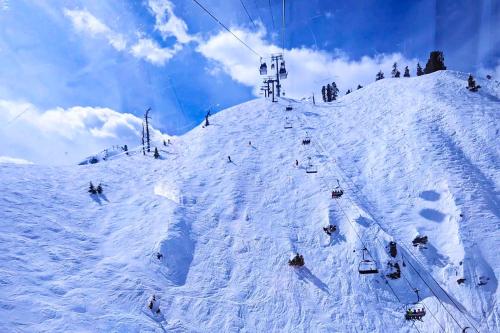 a group of people skiing down a snow covered slope at Tavern Inn #15 in Olympic Valley