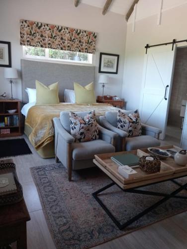 a bedroom with a bed and a couch and a table at 19, Ridge House in St Francis Bay