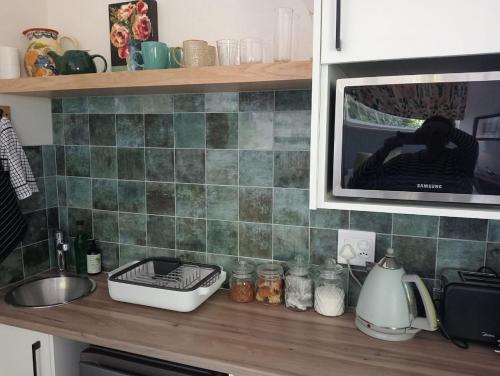 a kitchen counter with a sink and a microwave at 19, Ridge House in St Francis Bay