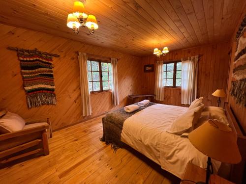 a bedroom with a bed in a log cabin at Green Baker Lodge in Puerto Bertrand