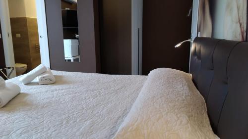 a white bed with two towels on top of it at CconfortHotels R&B Central Rooms in Bari